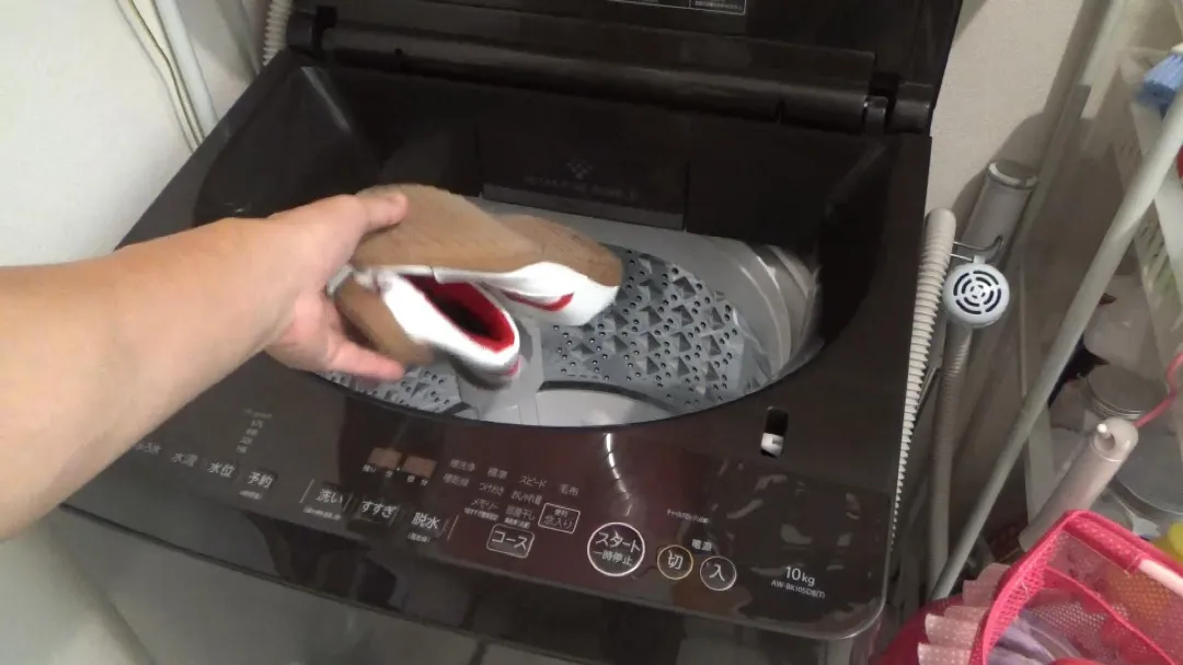 洗い終わった靴を洗濯機に入れて脱水する画像